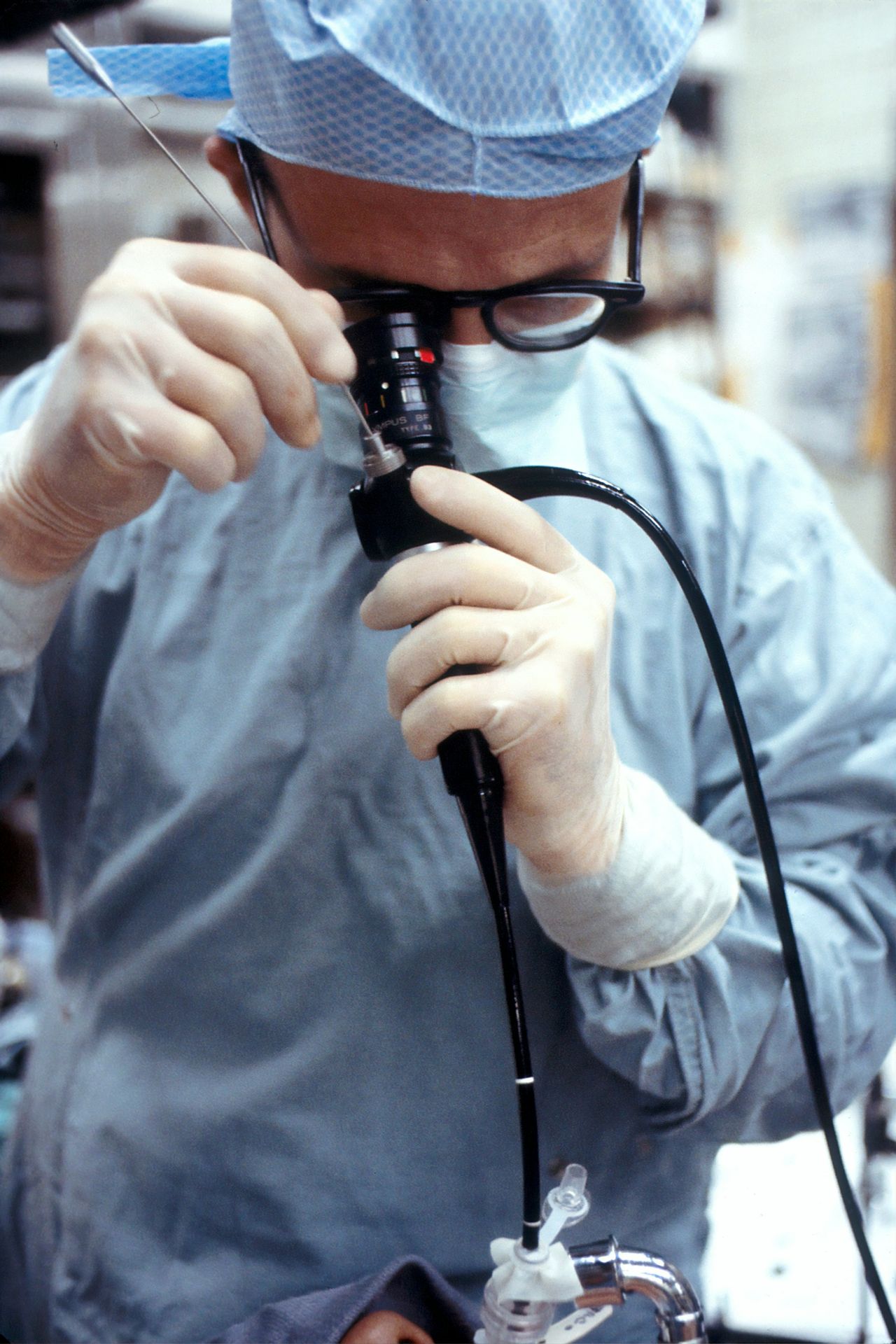 man in blue dress shirt holding black corded device